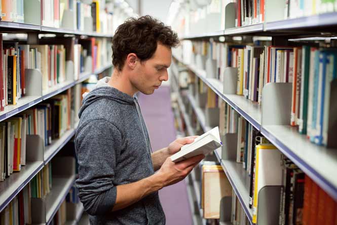 Une voie exigeante Élève lisant en bibliothèque