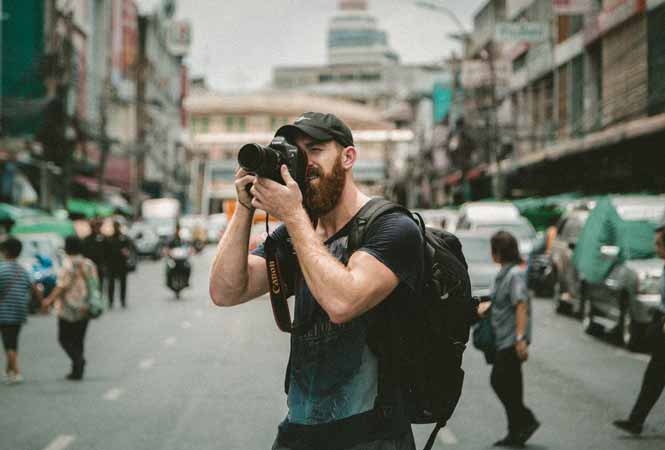 Photographe prenant une photo dans une rue
