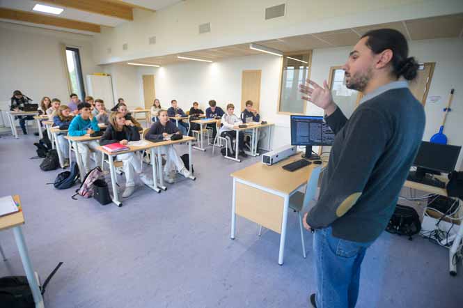 Un professeur donne un cours à ses élèves dans une salle de classe d&#039;un lycée
