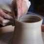 Mains qui travaillent sur un vase en céramique
