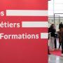 Vue d&#039;un salon d&#039;orientation avec un panneau indiquant &quot;Infos métiers formations&quot;