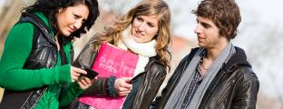 Trois jeunes discutent dehors