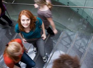 Lycéenne qui s'arrête dans un escalier