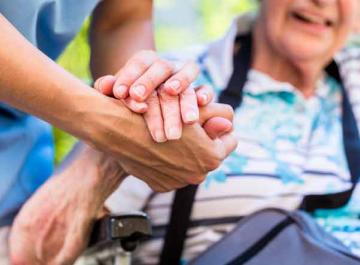 Personne âgée accompagnée par un professionnel de l'aide à domicile