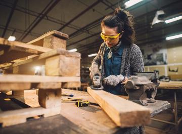 Une personne usine une pièce de bois