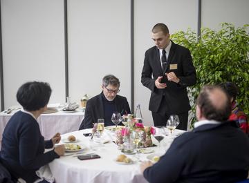 Un élève en formation en hôtelière sert des clients