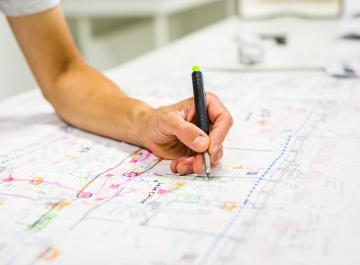 Une personne écrit sur un plan