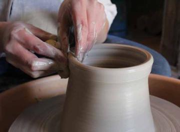 Mains qui travaillent sur un vase en céramique