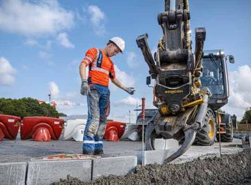Un constructeur de route guide un engin de chantier