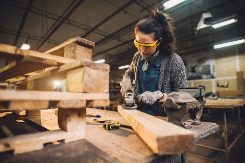 Une personne usine une pièce de bois