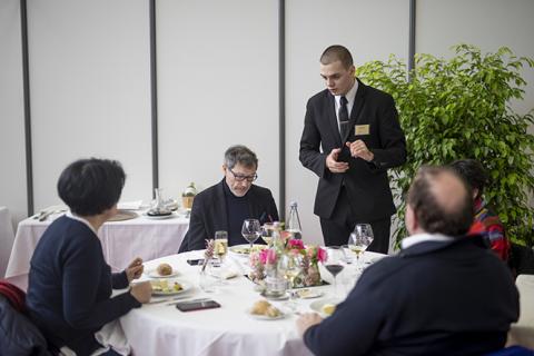 Un élève en formation en hôtelière sert des clients