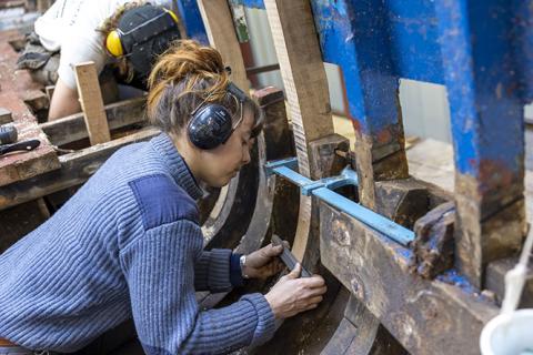 Jeune femme travaillant sur la charpente