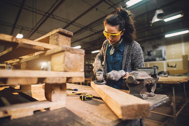 Une personne usine une pièce de bois