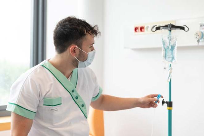 Infirmier Infirmier qui vérifie une perfusion
