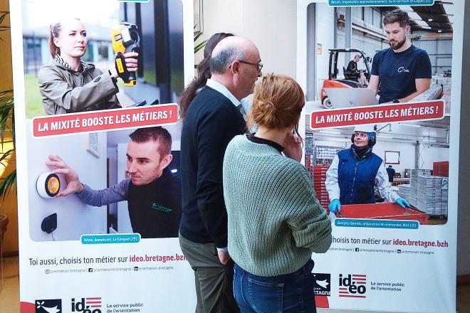 Une exposition pour valoriser la diversité des profils dans le monde professionnel Un groupe de personnes devant la série de portraits "La mixité booste les métiers!"