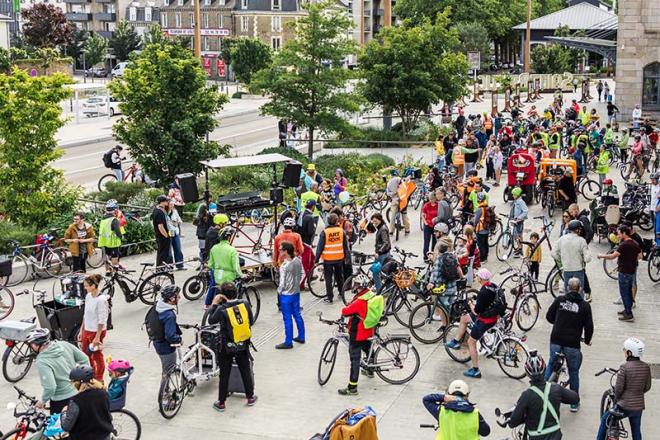 Des festivaliers se rendent à vélo au festival Art Rock. Une foule de personnes à vélo.