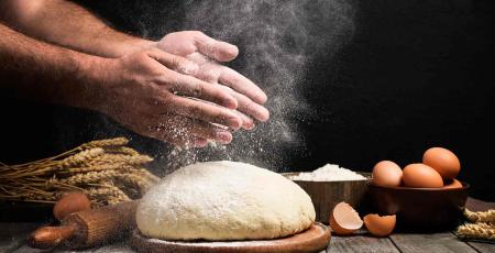 Des mains au-dessus d&#039;une pâte à main