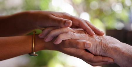 Une main soutient une main de personne âgée
