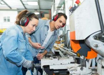Jeune femme qui apprend à se servir d'une machine